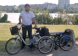 cyclist posing in front of tricycle