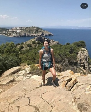 a hiker standing atop a hill posing for a photo