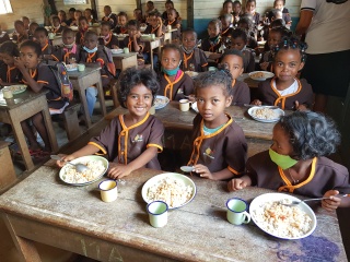 a classroom full of children with food in front of them
