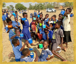 group of children holding brightly coloured mugs up to the camera