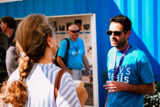 Two Mary's Meals supporters talking to each other outside the Mary's Meals information centre in Medjugorje.