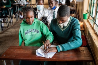 two students poring over an open book