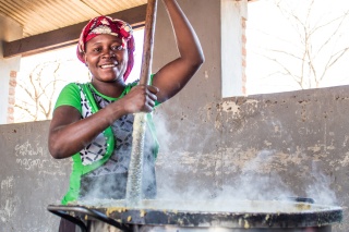 A Mary's Meals volunteer preparing food for the children at school. 