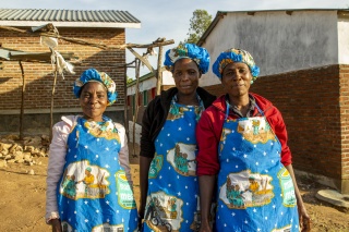 Mary's Meals Malawi volunteer cooks smiling with their aprons on. 