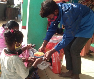 Man handing out food to young children