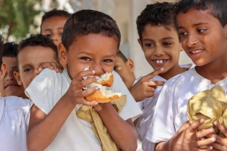 Children from Yemen enjoying Mary's Meals in their place of learning.