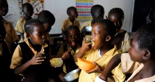 Children eat food together in class