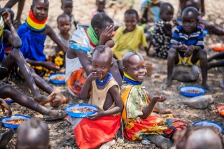 Children enjoying a meal outside in Kenya.