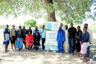 Community leaders, partners and volunteers posing for a photo outside of a school in Zimbabwe.