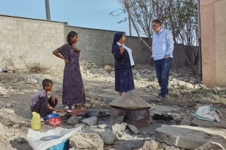 Picture of Magnus with Sister Medhin talking with a mother and her child.