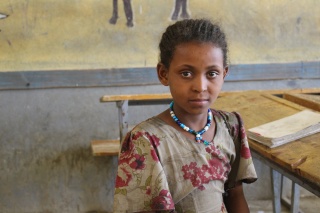 Image of Mahlet sitting in a classroom looking into camera. 