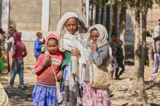 Image of a family who had gathered at the school looking into the camera.