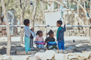 Children eating their school meal in the playground.