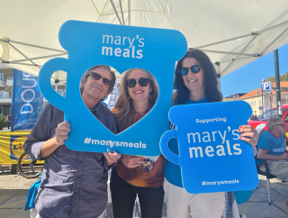 Mary's Meals volunteers and supporters holding signs.