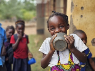 A happy girl in Zambia after finishing her Mary´s Meals porridge at school